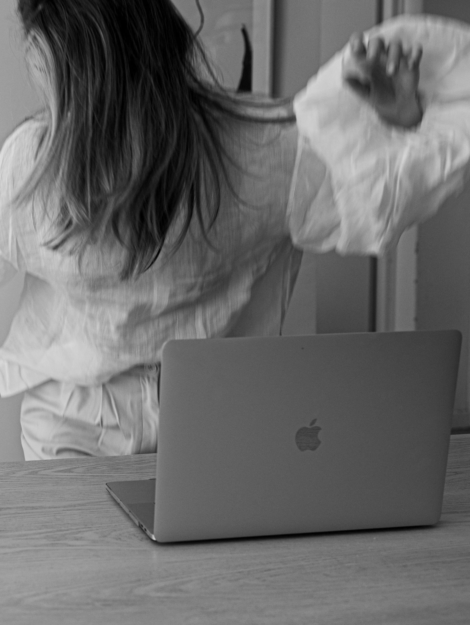 black and white image of a woman moving and laptop